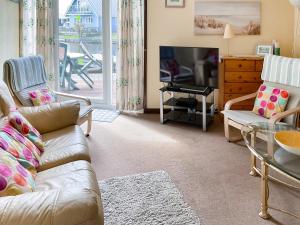 a living room with a couch and a television at Ripples in Horning