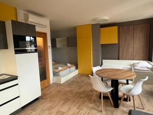 ein kleines Zimmer mit einem Tisch, Stühlen und einem Bett in der Unterkunft Yellow apartment Deluxe in Brünn