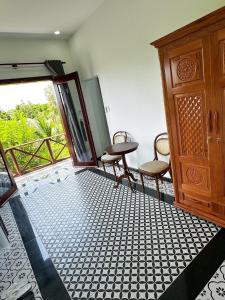 a room with a table and two chairs and a door at Rạch sao eco garden in Phong Ðiền