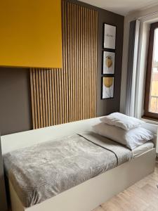 1 dormitorio con 1 cama con pared amarilla en Yellow apartment Deluxe, en Brno