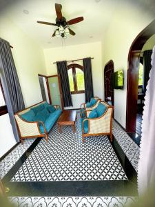 a living room with two chairs and a couch at Rạch sao eco garden in Phong Ðiền