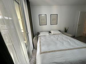 biała sypialnia z łóżkiem i oknem w obiekcie Annecy gare w Annecy