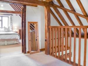 The Old Stable - Meadowbrook Farm في تايم: غرفة بها درج يؤدي إلى غرفة النوم