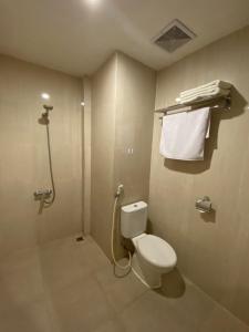 a bathroom with a toilet and a shower at Front One Budget Malang by Azana in Malang