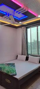 Zimmer mit einem Bett in einem Zimmer mit Fenstern in der Unterkunft Hotel khatushyamji palace in Khātu