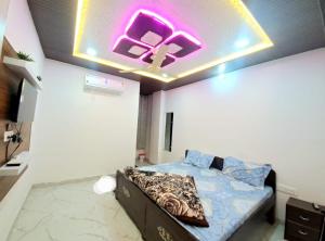 a bedroom with a bed with a neon sign on the ceiling at Hotel khatushyamji palace in Khātu