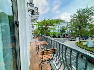 Un balcón con 2 sillas, una mesa y una calle en KHÁCH SẠN THƯ LÊ LUXURY en Cao Lãnh