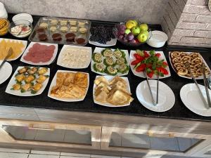 um buffet com muitos tipos diferentes de alimentos em pratos em Hotel Ishonch em Samarkand