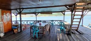 a wooden deck with a table and chairs on a boat at Ekas beach floating Room and suite in Ekas