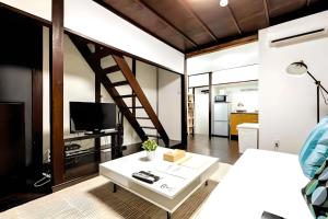 a room with a bed and a table with a tv at Yagara Terrace House A in Osaka