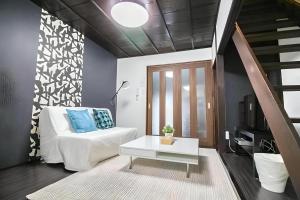 a living room with a white couch and a table at Yagara Terrace House A in Osaka