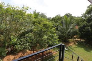 a balcony with a fence and some trees at Kumbuk Sewana Villa in Anuradhapura