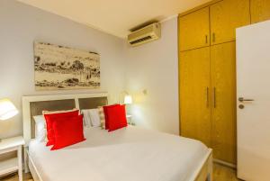 sypialnia z białym łóżkiem z czerwonymi poduszkami w obiekcie One Bedroom With Private Balcony w Kapsztadzie
