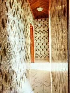 an empty hallway with a stone wall and a room with a hallway at residence des coeurs gabriella in Kribi