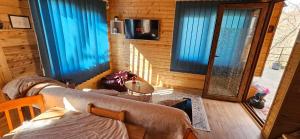 a room with a bed and a window with blue curtains at Cottage lima in Kutaisi