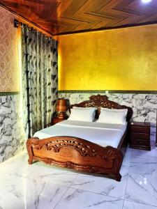 a bedroom with a large bed with a wooden frame at residence des coeurs gabriella in Kribi