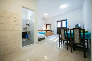 a bedroom with a bed and a table and a bathroom at Seafront apartment Jurkovica in Komiža