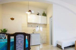 a small kitchen with a sink and a refrigerator at Seafront apartment Jurkovica in Komiža