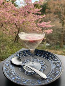 una bebida en un plato con dos cucharas en una mesa en HOTEL LT Kitchen 湯河原, en Yugawara