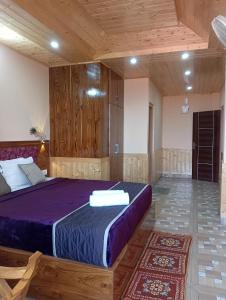 um quarto com uma cama grande num quarto com tectos em madeira em Atithi Homestay & Bhojnalya, Chail em Chail