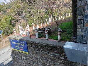 a stone wall with fire hydrants in a cemetery at Atithi Homestay & Bhojnalya, Chail in Chail