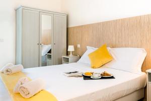 a large white bed with a tray of food on it at Hotel Aria di Mare in Marina di Ragusa