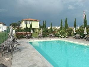 a swimming pool with chairs and umbrellas and a house at Villa Manuela in Altopascio