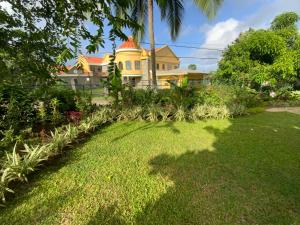 a yellow house with a lawn in front of it at Marvey's Place in Castries