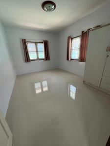 een lege kamer met 2 ramen en een badkamer bij บ้านมณียา in Noen Kra Prauk