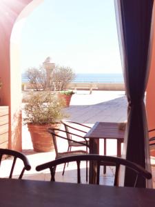 - une table et des chaises sur une terrasse avec vue sur la plage dans l'établissement Appartement dans Village vacances vue mer, à Saint-Raphaël