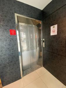 an elevator in a building with a sign on the wall at Bergamo Hotel Pekeliling Kuala Lumpur in Kuala Lumpur