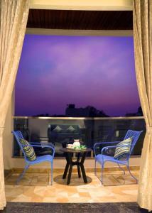 un patio con 2 sillas y una mesa con vistas en Sumadhu Homes -Family Homestay en Kolhapur