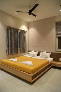 1 dormitorio con 1 cama grande y ventilador de techo en Sumadhu Homes -Family Homestay en Kolhapur