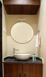 La salle de bains est pourvue d'un lavabo et d'un grand miroir. dans l'établissement Sumadhu Homes -Family Homestay, à Kolhapur