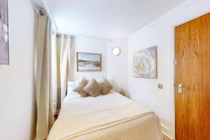 a small bedroom with a bed and a window at Park Lane Apartments Mayfair Collection in London