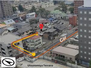 une vue aérienne d'une ville avec un panneau d'arrêt dans l'établissement Guesthouse Kincha 駅東口, à Utsunomiya