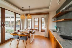 a kitchen with a wooden table and a dining room at Om Ham Retreat and Resort in Ubud
