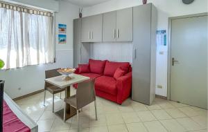a living room with a red couch and a table at Nice Apartment In Marzamemi in Marzamemi +9 photos