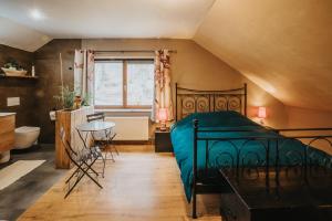 a bedroom with a bed and a table and a window at Le refuge de Kila in Waimes