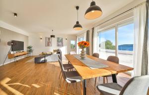 a dining room with a table and chairs and a large window at Beautiful Home In Sevid Na Moru in Sevid