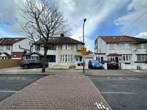 a parking lot with cars parked in front of buildings at House Dollis Hill in London