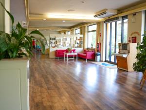 a large room with wooden floors and pink furniture at Hotel Regent in Pescara