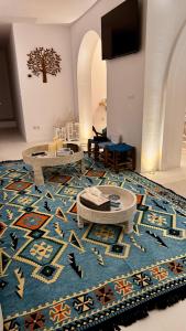 een woonkamer met een blauw tapijt en tafels op een vloer bij Casa Blu Marbella in Marbella