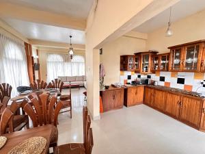 cocina y comedor con mesa y sillas en Maples Holiday Resort, en Nuwara Eliya