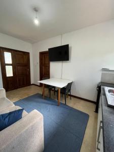 ein Wohnzimmer mit einem Tisch und einem Flachbild-TV in der Unterkunft Golden Bean Grove in Lusaka