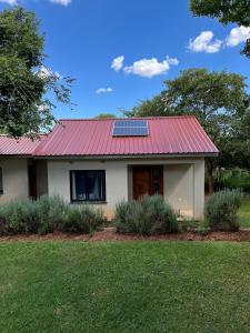 una casa con techo rojo con un panel solar. en Golden Bean Grove, en Lusaka