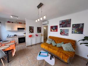 a living room with a couch and a kitchen at Rivage hyper centre et plage a pied in Le Barcarès