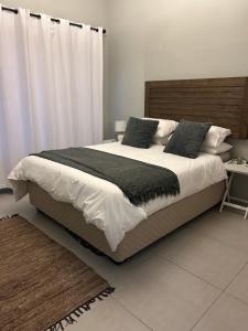 a bedroom with a large bed with a wooden headboard at SOMS Langstrand Self Catering in Langstrand