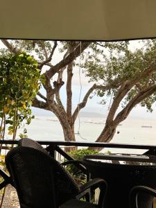 Pescador View - Beach Resort & Restaurant في موالبوال: اطلالة على المحيط من طاولة وكراسي