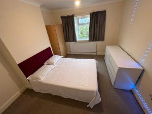 a small room with two beds and a window at House Dollis Hill in London